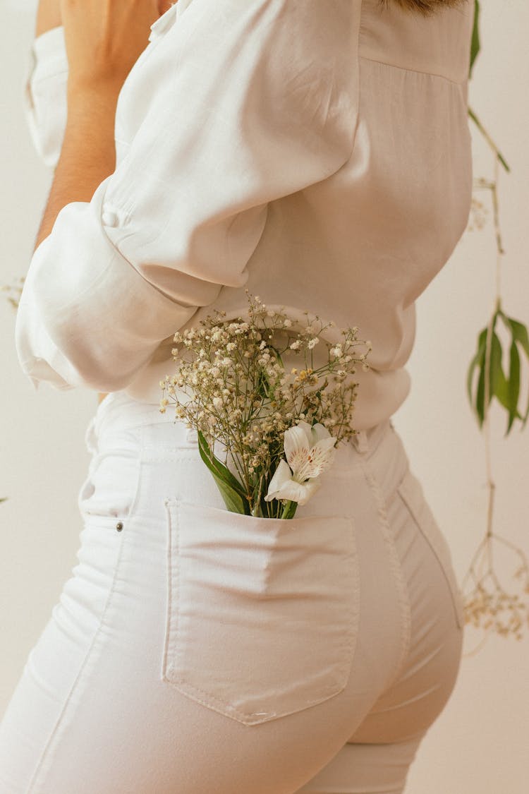 Close-up Of Woman With Wildflowers In Pants Pocket