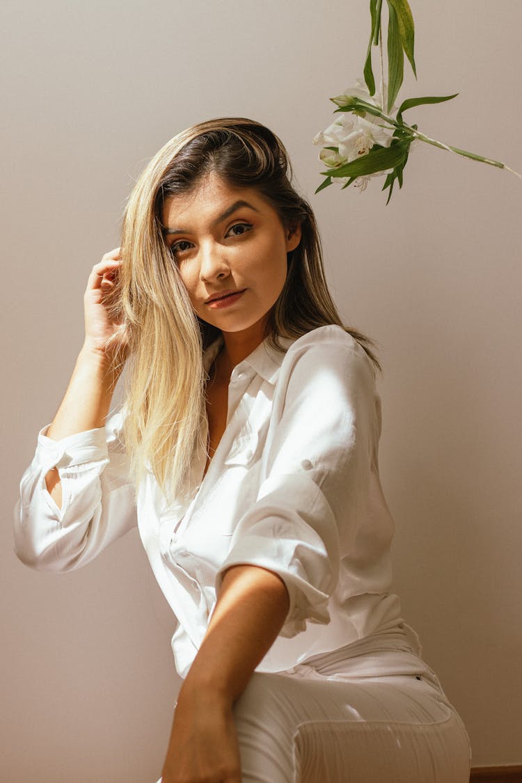 A Woman In White Long Sleeve Shirt Beside A Hanging Flower 