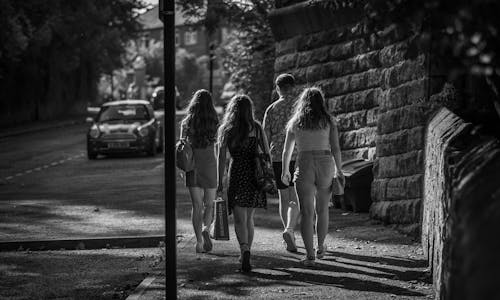 Grayscale Photography of People Walking on the Sidewalk of the Road