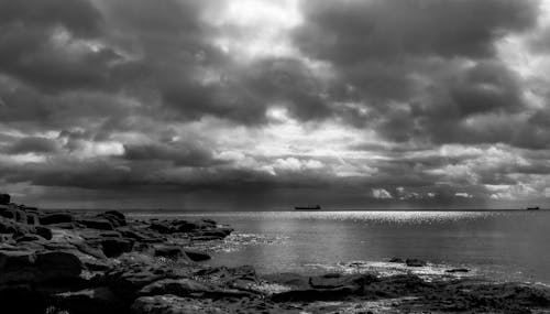 Grayscale Photography of a Boat Sailing on the Sea