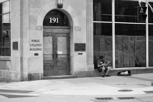 Black and White Photo of Man Playing Violin on Street