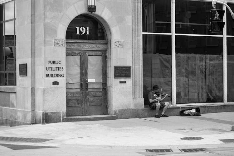 Black And White Photo Of Man Playing Violin On Street