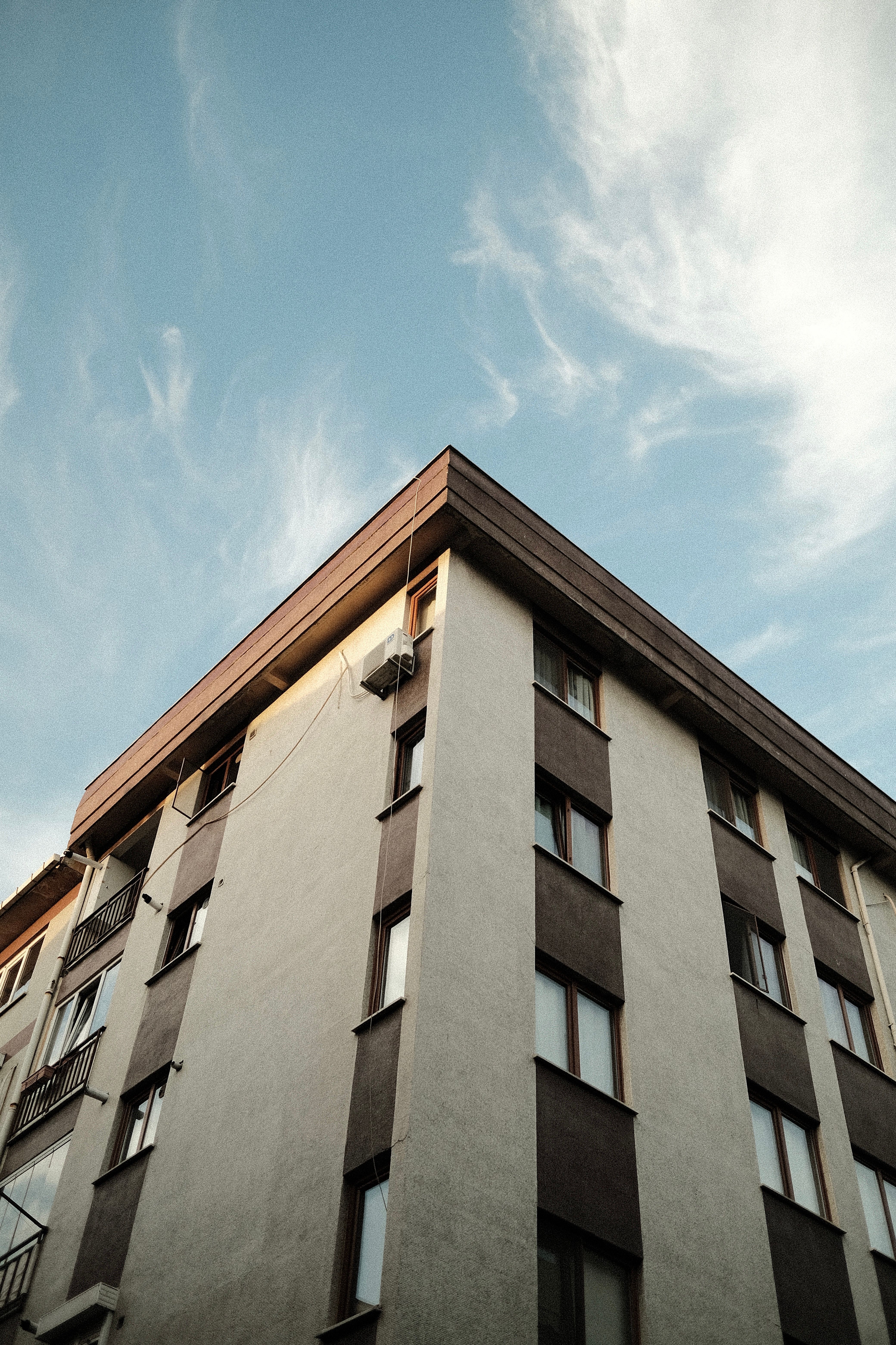Low Angle Shot of Brown Concrete Building Under Blue Sky · Free Stock Photo