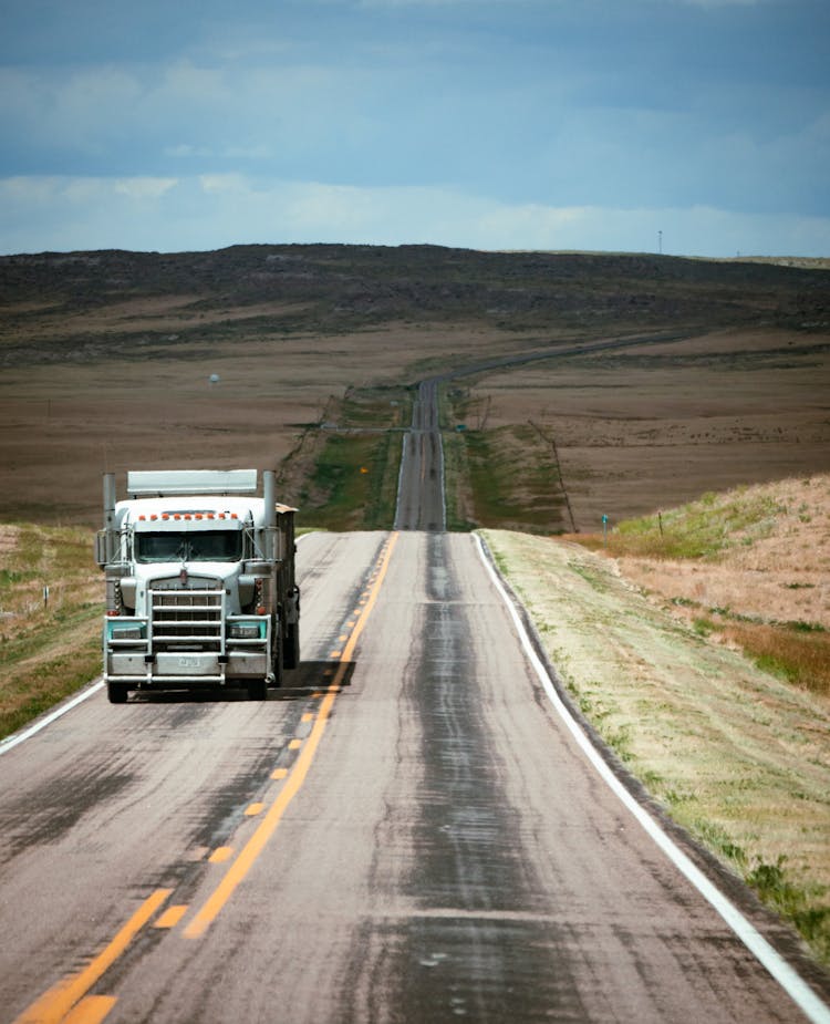 A White Truck On Road Near A Hill