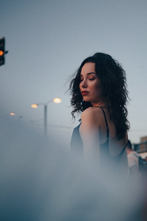 A Woman in Black Tank Top Looking Over Her Shoulder