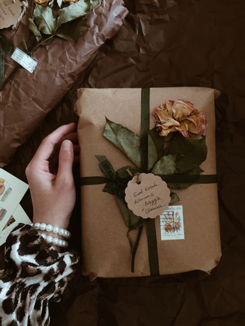 Free Handcrafted gift wrapped in brown paper with dried flowers and handwritten label, perfect for special occasions. Stock Photo