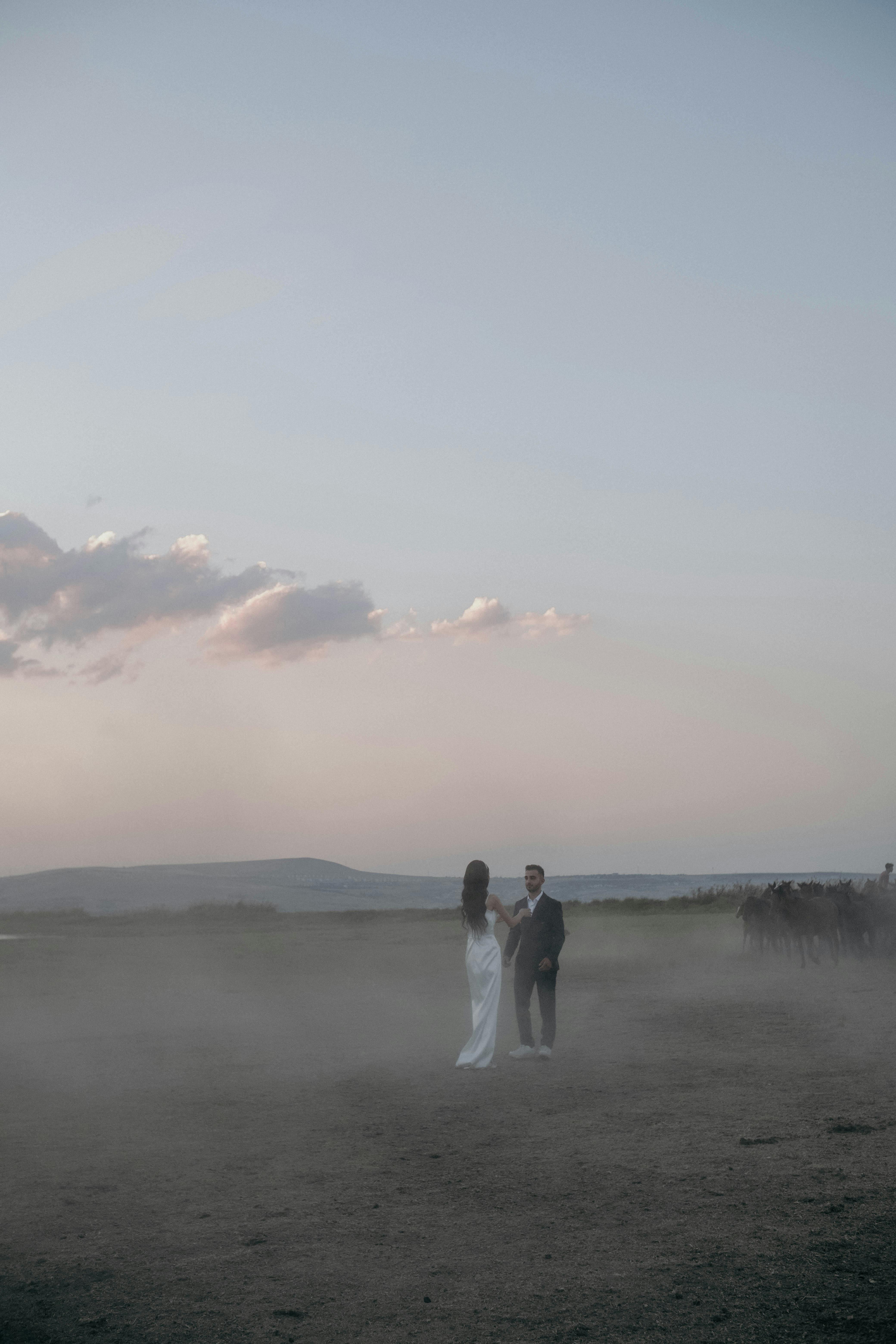 couple standing on dusty field