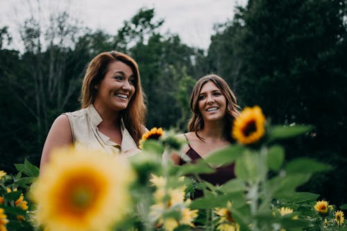 Two Women Standing On Sunflower Garden