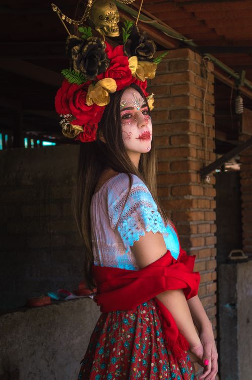 Free Portrait of a woman in Day of the Dead makeup and traditional attire. Stock Photo