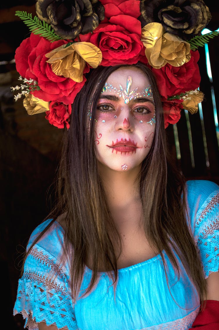 A Woman With Face Paint Wearing A Floral Headdress