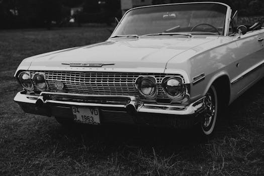 Classic 1963 Chevrolet convertible, parked on grass in a vintage black and white photo.