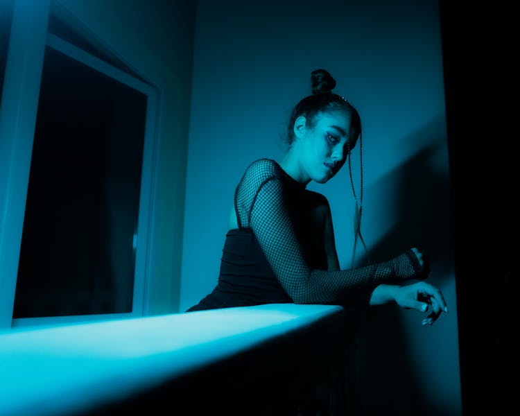 A Woman In Black Top Leaning On A Counter