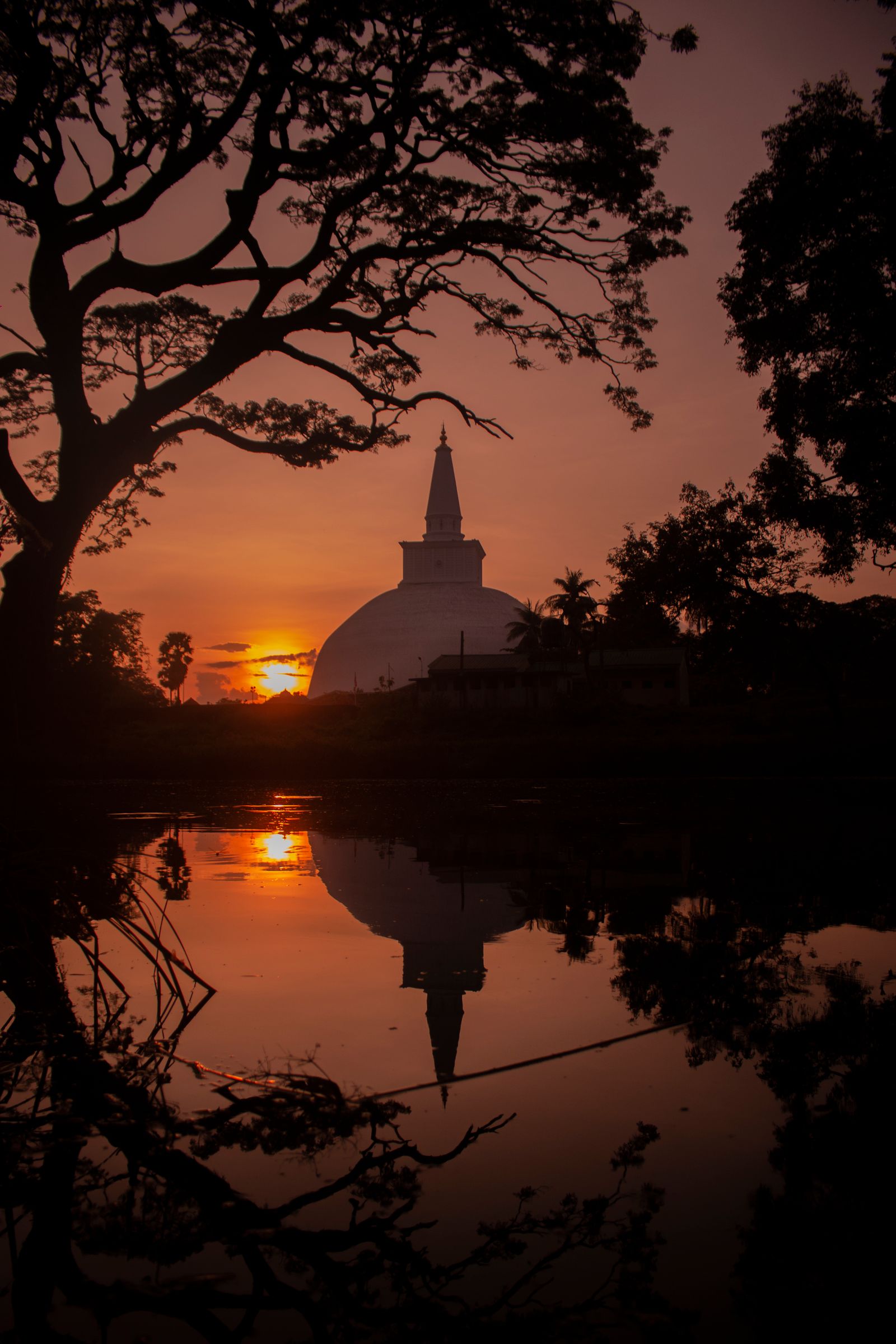 Ancient stupa reflected in water at sunset in Anuradhapura