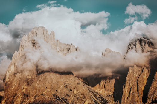 Breathtaking view of Dolomites peaks enveloped by clouds under a blue sky. Perfect for nature enthusiasts.