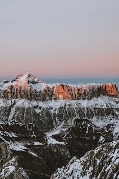 日出时，多洛米蒂山白雪皑皑的山峰与宁静的天空构成了一幅壮丽景色