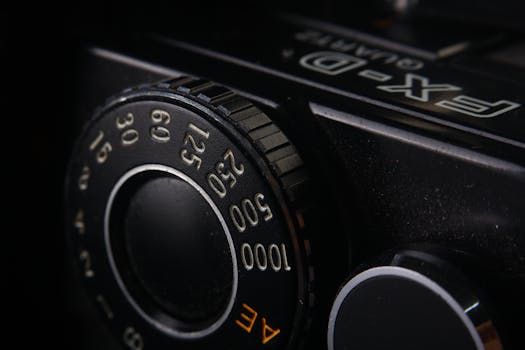 Macro shot of a vintage camera dial showing numbers and settings.