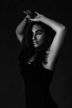 Artistic black and white portrait featuring a woman posing with elegance and style.
