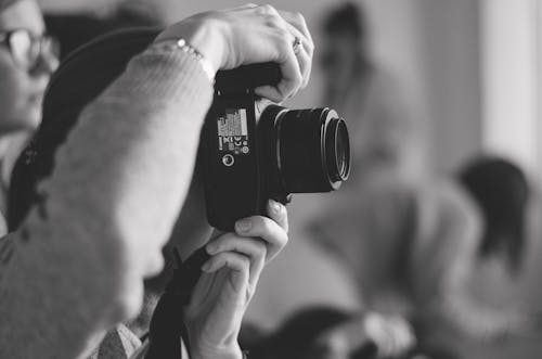 Grayscale Photo of a Person Taking Photo