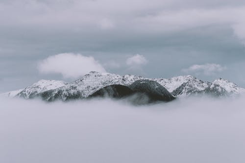 Монохромная фотография горы, покрытой облаками