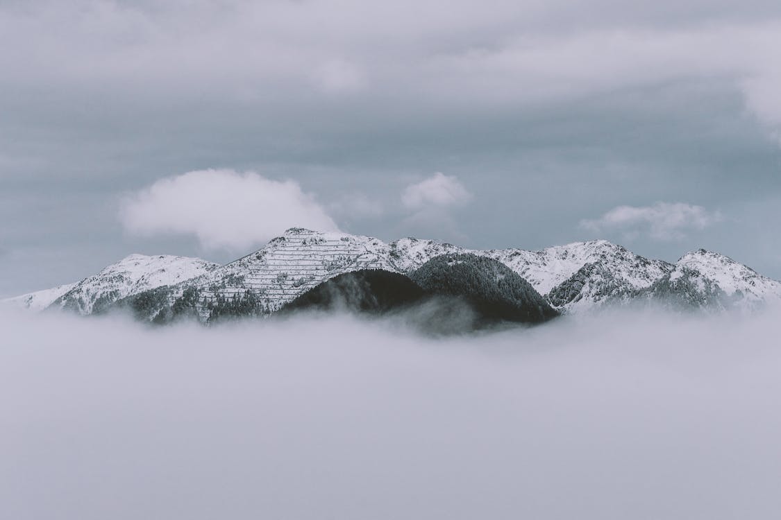 Monochrome Photography Of Mountain Covered by Clouds