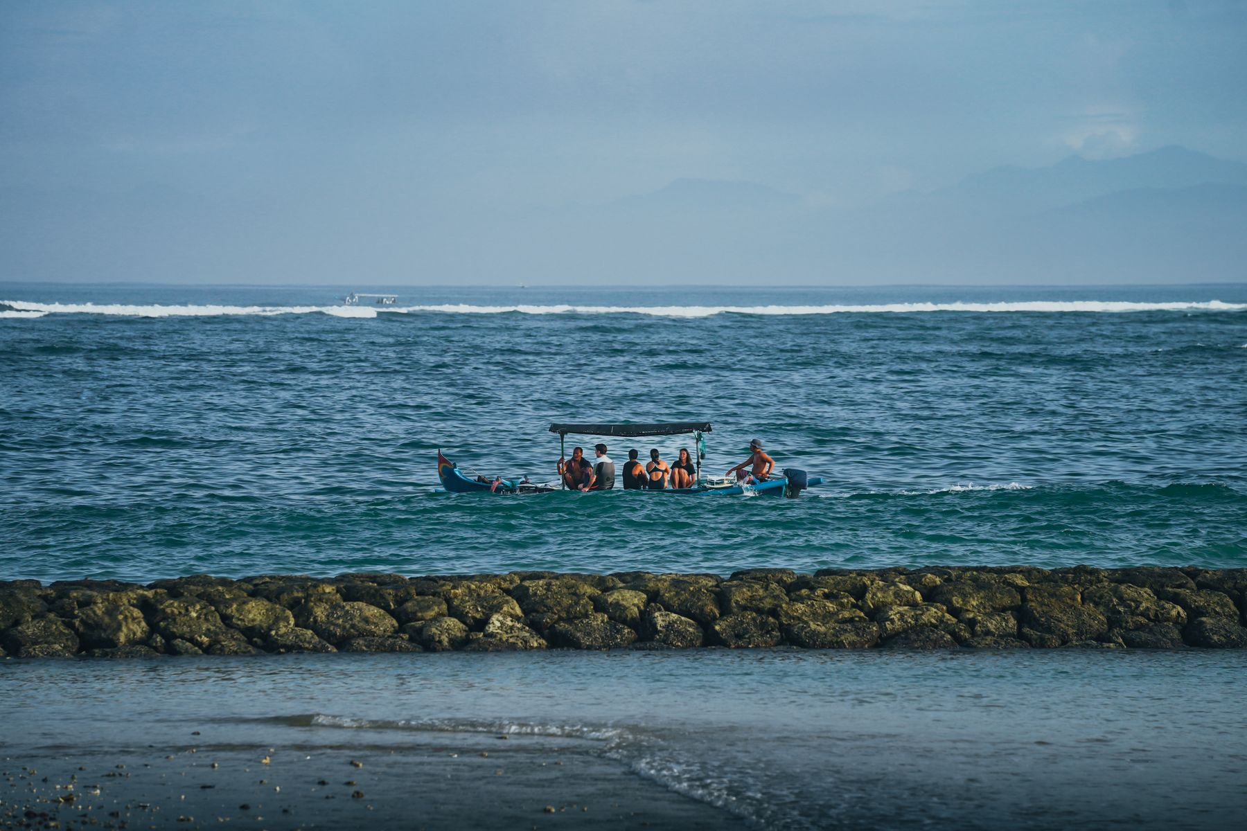 Small passenger boat on wavy Bali water