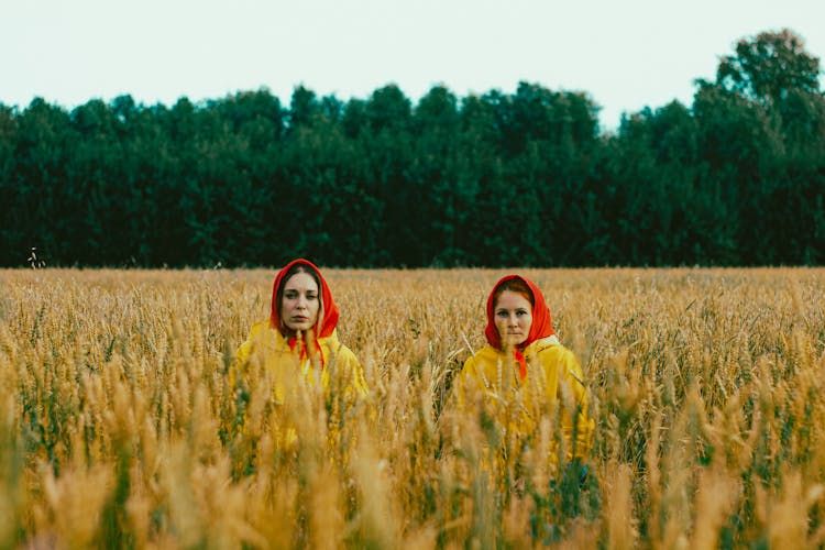 Women In Yellow Coats And Red Handkerchiefs In Field