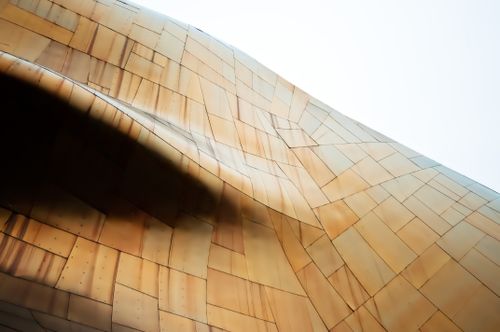Free Close-up of modern architecture with a unique bronze metallic facade in flowing contours. Stock Photo