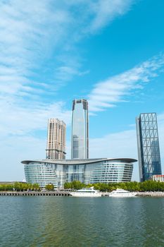 Futuristic skyline of Tianjin's financial district with yachts in summer.