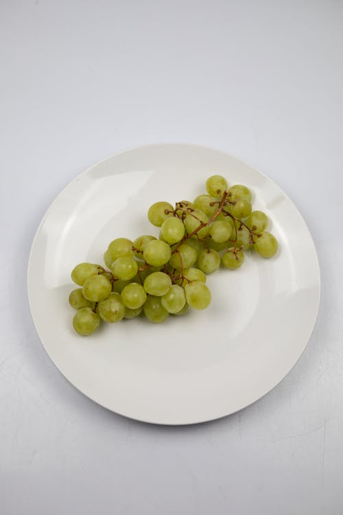 A Cluster Green Grapes  on White Ceramic Plate