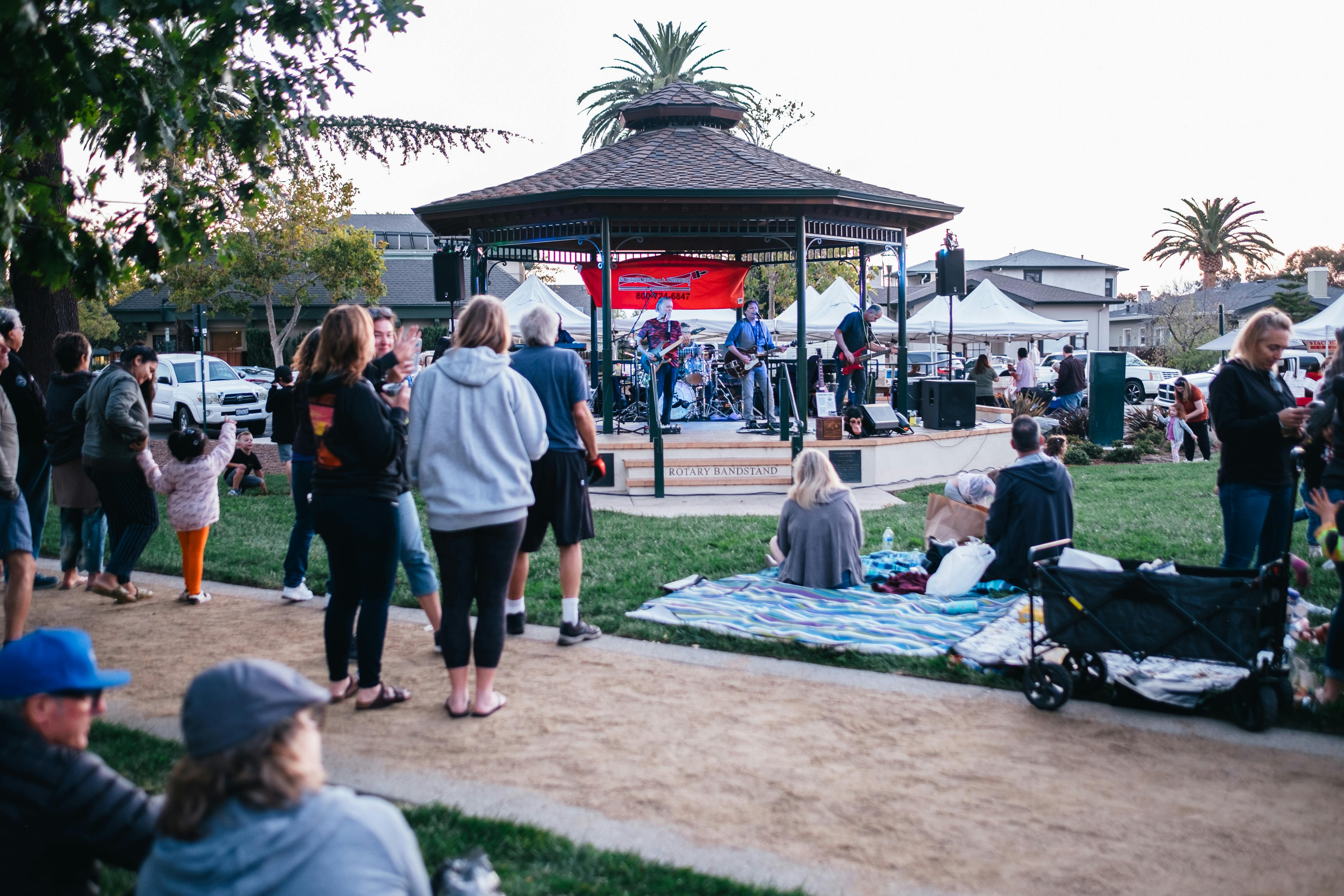 An outdoor concert in a Livermore park with people enjoying music and a vibrant atmosphere.