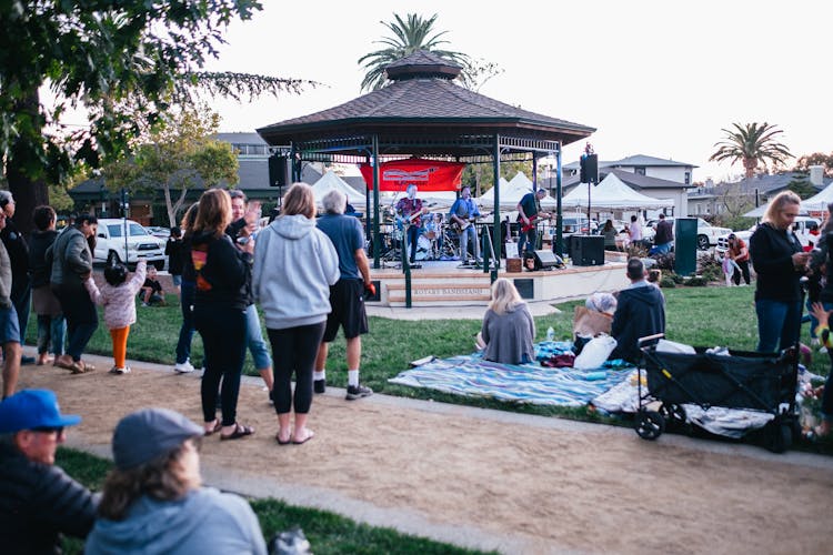 People Relaxing At Festival In Park