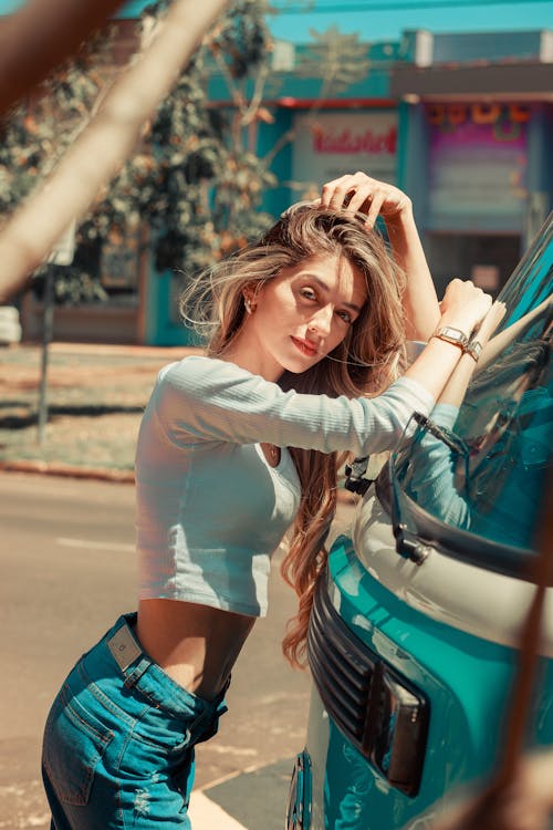 A Woman Standing and Posing Beside the Vehicle