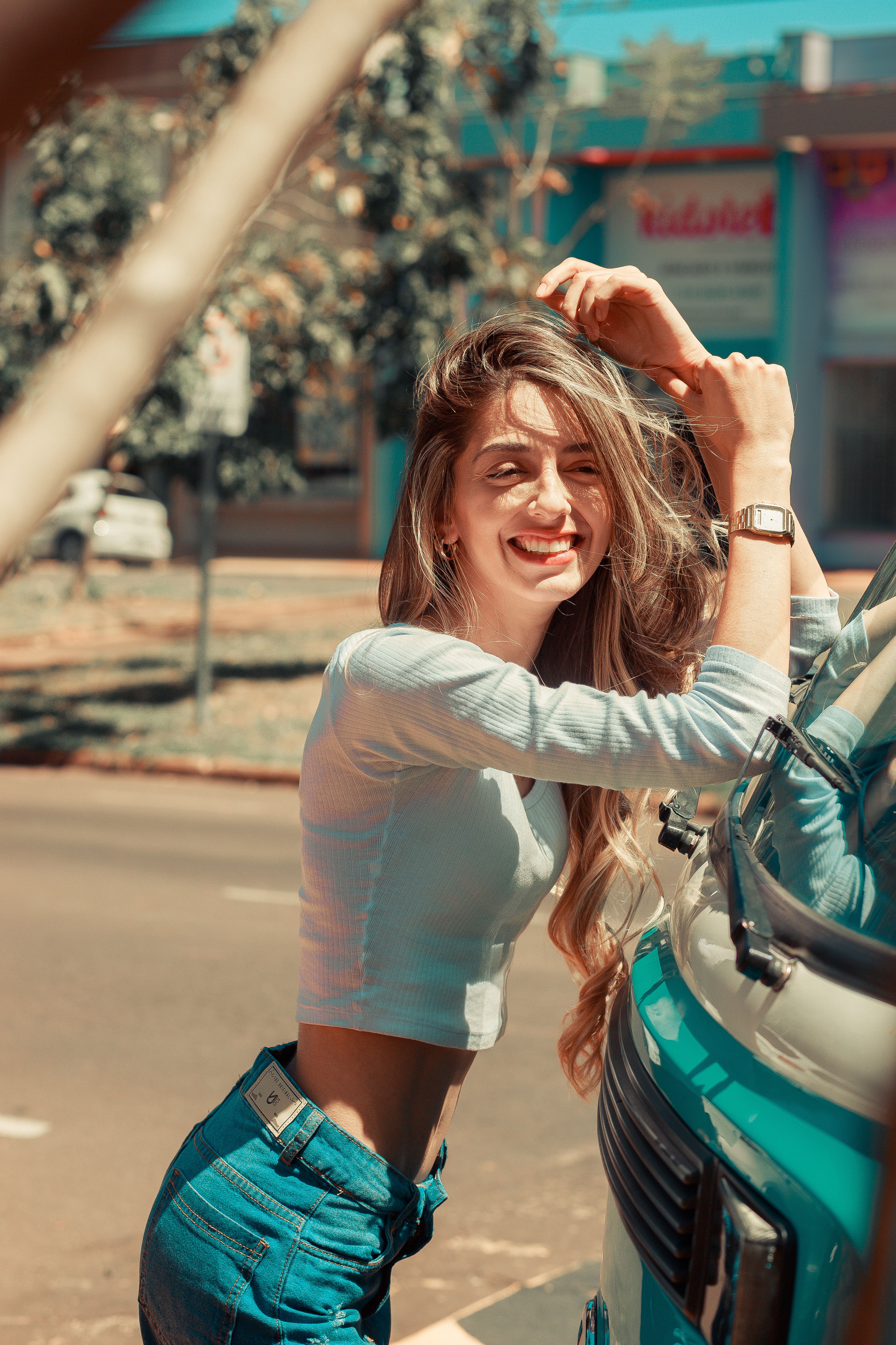Woman in White Long Sleeve Shirt and Blue Denim Shorts Leaning on a Car ...