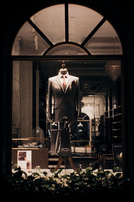 Stylish men's suit displayed in a boutique window. Elegant fashion under warm lighting. Stylish men's suit displayed in a boutique window. Elegant fashion under warm lighting.