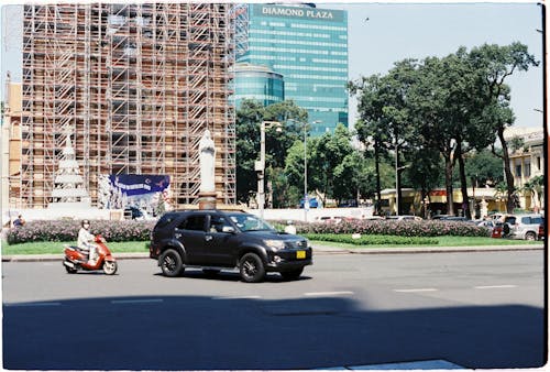 Black Suv on Road Near High Rise Buildings