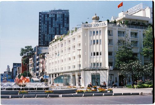 Free View of Rex Hotel and surrounding cityscape in Ho Chi Minh City with a fountain in the foreground. Stock Photo