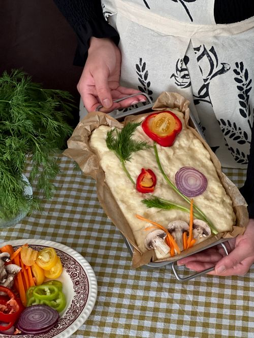 Free Focaccia bread preparation with fresh vegetables in a baking tray. Stock Photo