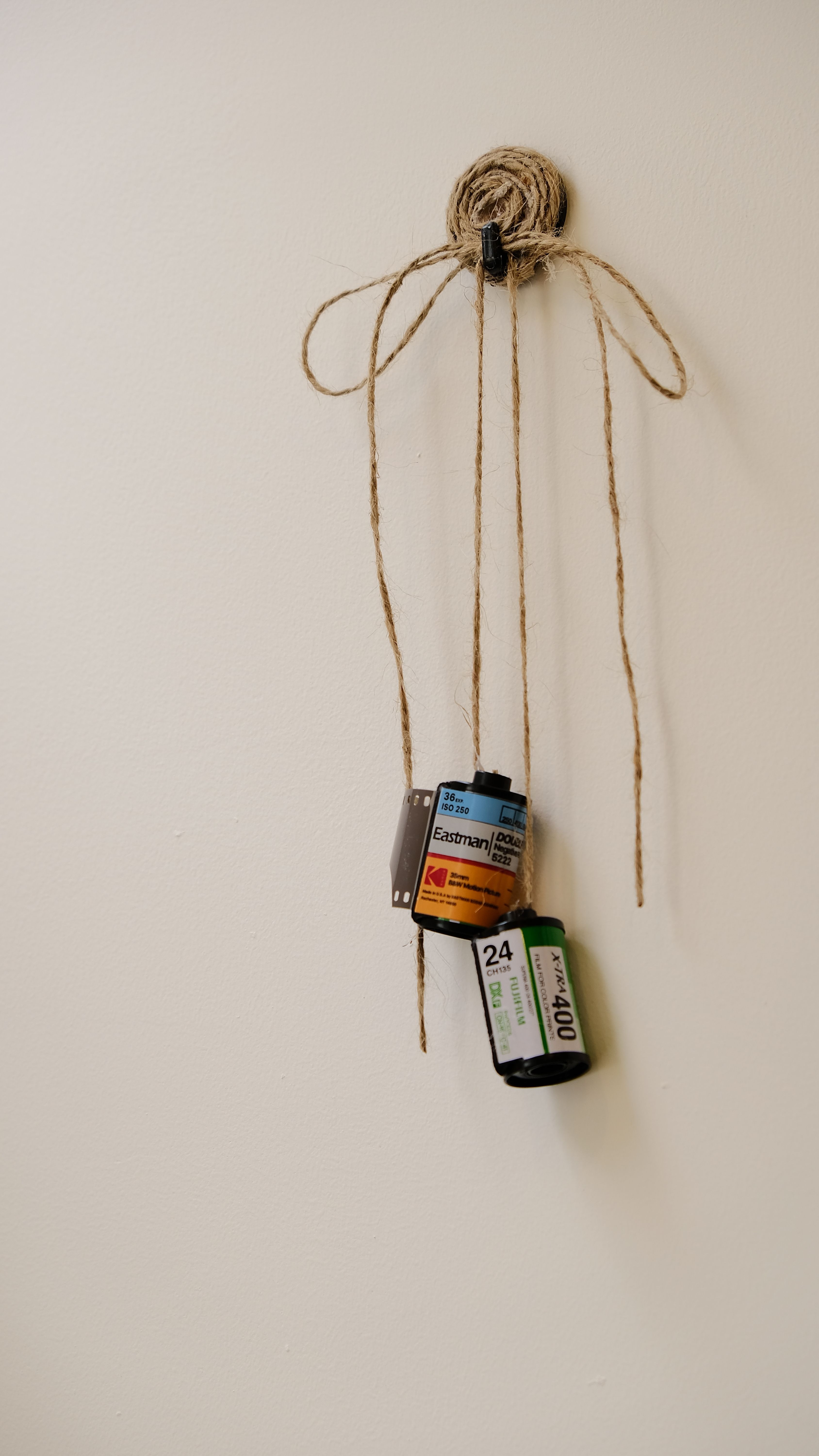 Creative wall decor using vintage film rolls and string for a retro aesthetic.