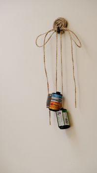 Creative wall decor using vintage film rolls and string for a retro aesthetic.