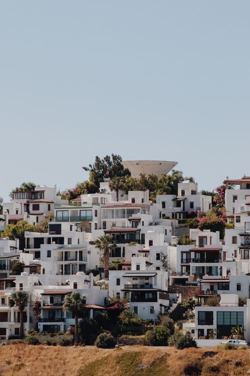 Free Charming white Mediterranean-style hillside houses with lush greenery. Stock Photo
