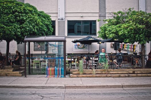 靠近热闹街道的公交车站，有一座城市露台，设有座位