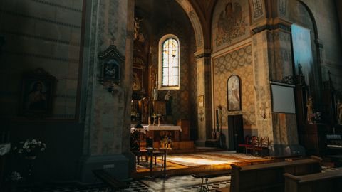 A beautifully lit interior of a historic Catholic church showcasing ornate architecture.