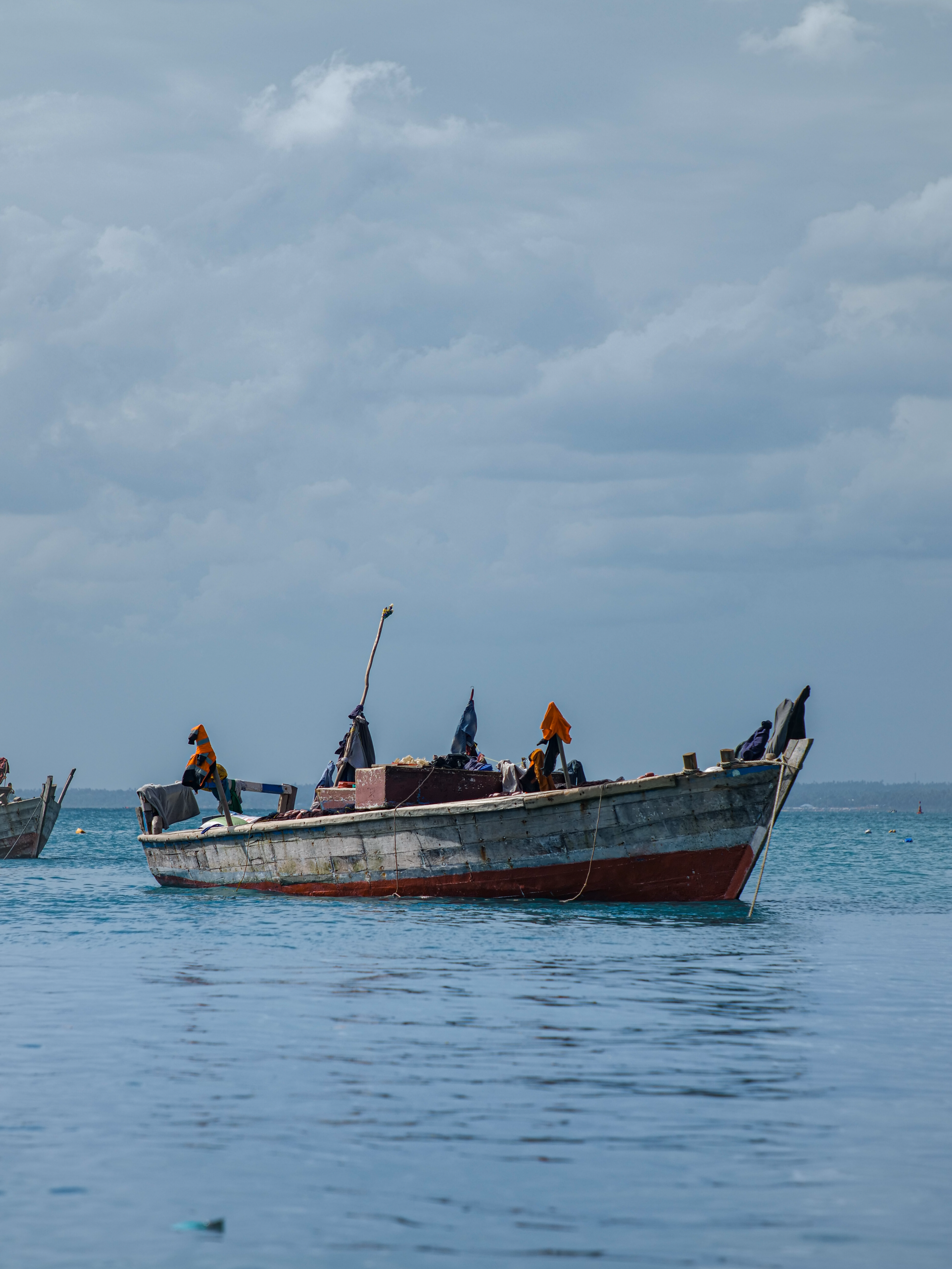 Wooden Boat on the Ocean under the Cloudy Sky · Free Stock Photo
