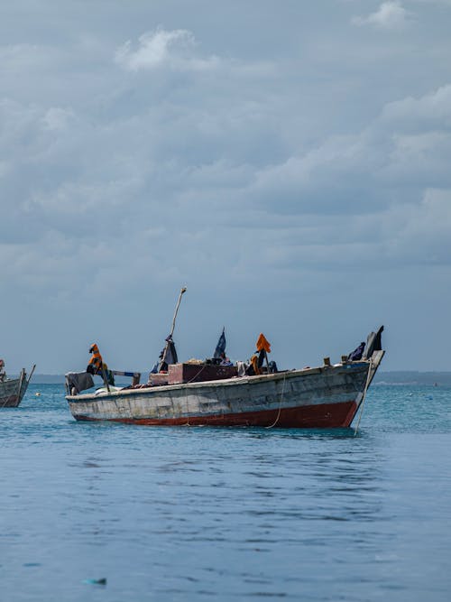 Wooden Boat on the Ocean under the Cloudy Sky