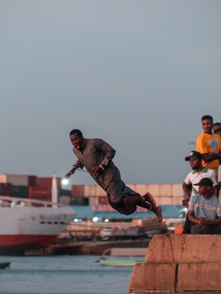 People Watching Man Jumping To Water