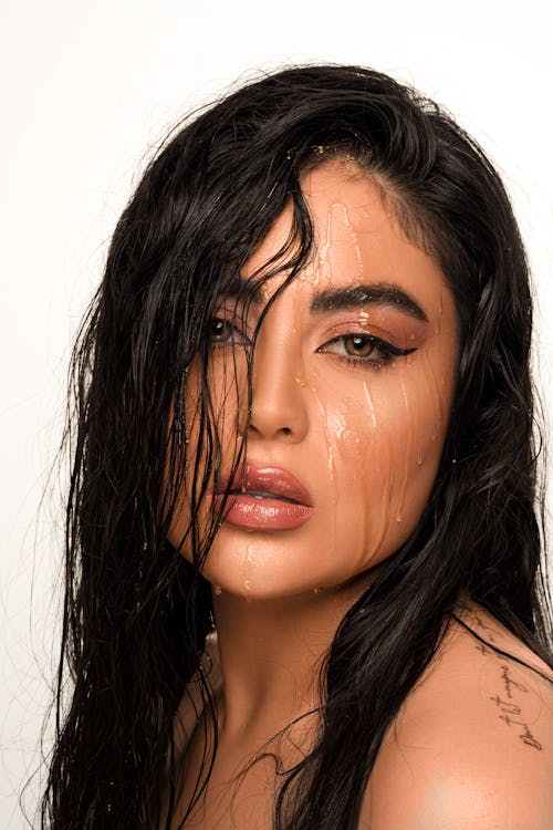 Beautiful Brunette Woman Posing with Water Running Down Her Face 