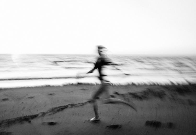 Person Running On Beach In Blurred Motion