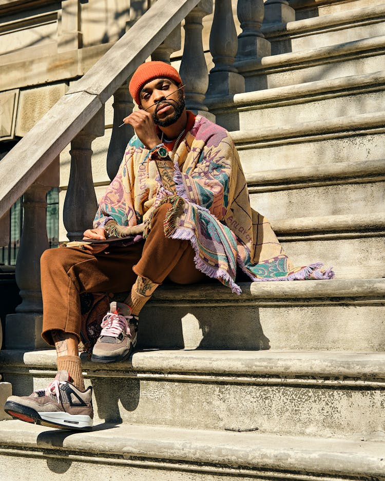 Man In Orange And White Dress Shirt Sitting On Stairs