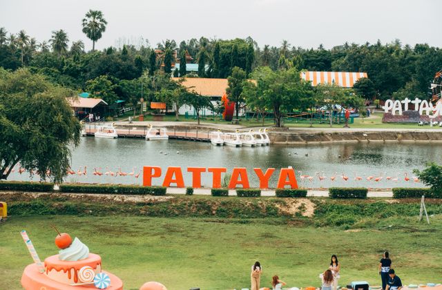 A vibrant scene in Pattaya, Thailand with a lake, iconic sign, and colorful decorations. — arriving in Pattaya