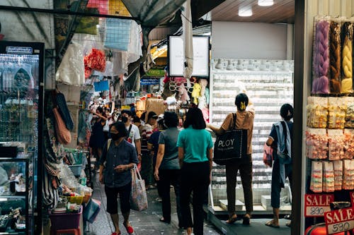 Shoppers Among Tightly Packed Stalls of a Bustling Market
